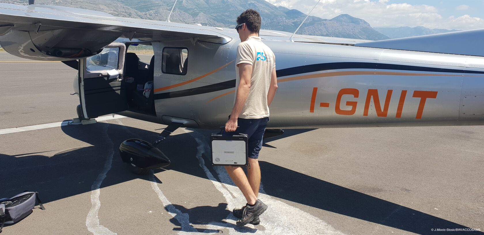 a man with a TOUGHBOOK infront of a plane